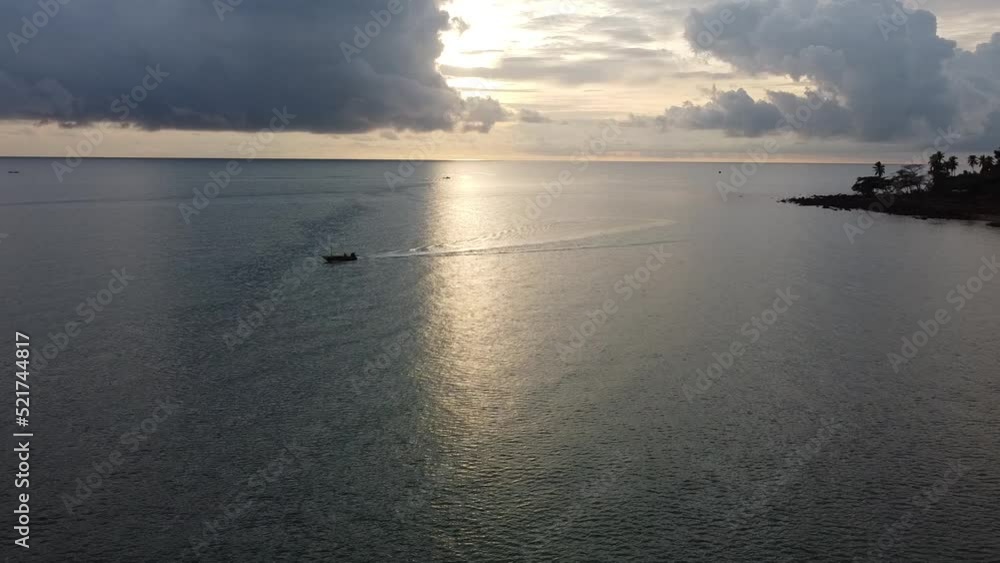 4K video captures the movement of one fishing boat on full speed drive with a sunset sky background. 4K video captures the movement of one fishing boat on full speed drive with a sunset sky background.