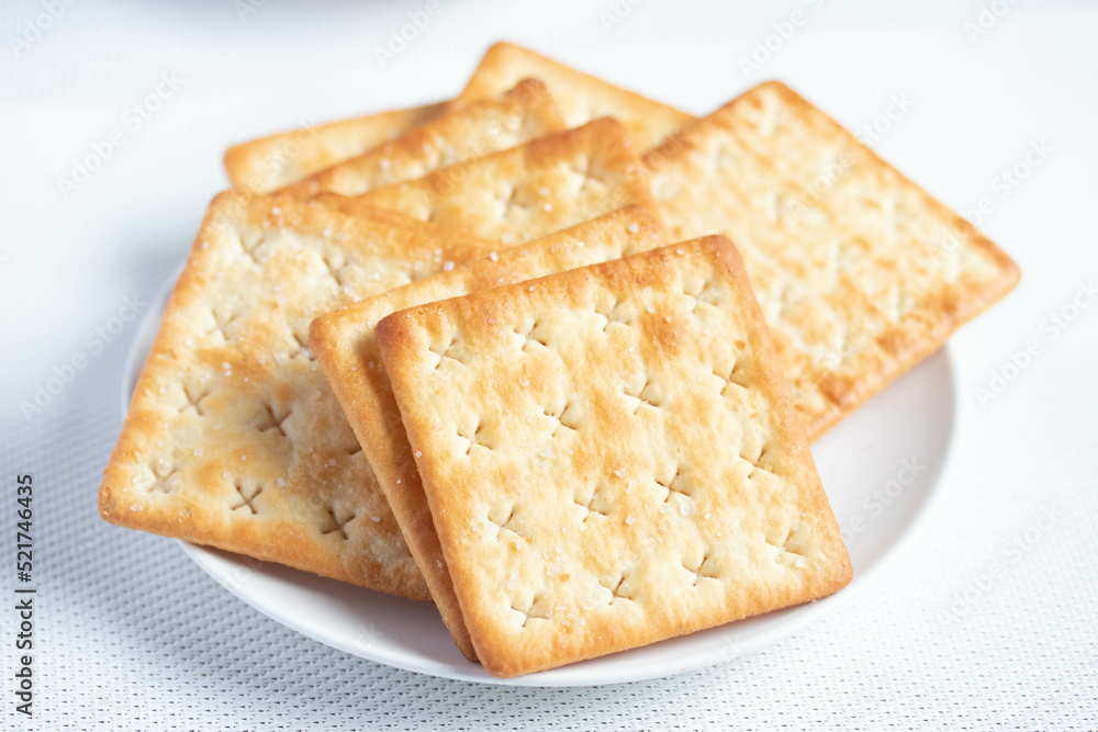 A pile of dry, thin crackers in a cup. Natural light. A pile of dry, thin crackers in a cup. Natural light.