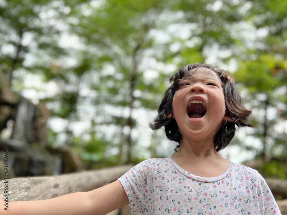 Cute little girl is laughing in the garden