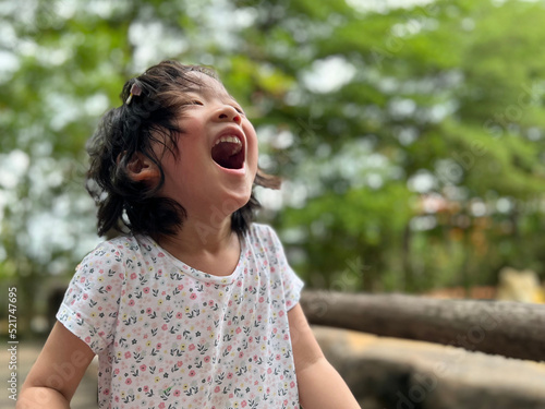 Cute little girl is laughing in the garden