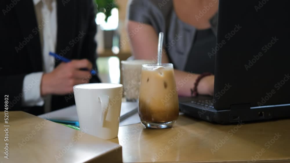 Waitress brings fresh coffee drinks to business people at cafe. Informal business meeting, remote job concept Waitress brings fresh coffee drinks to business people at cafe. Informal business meeting, remote job concept