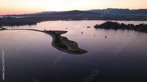 Aerial hyperlapse of ocean sunset, peninsula, boats in harbour, peaceful ocean sunset, Whiffen Spit, Sooke, Vancouver Island. 4K 24FPS photo