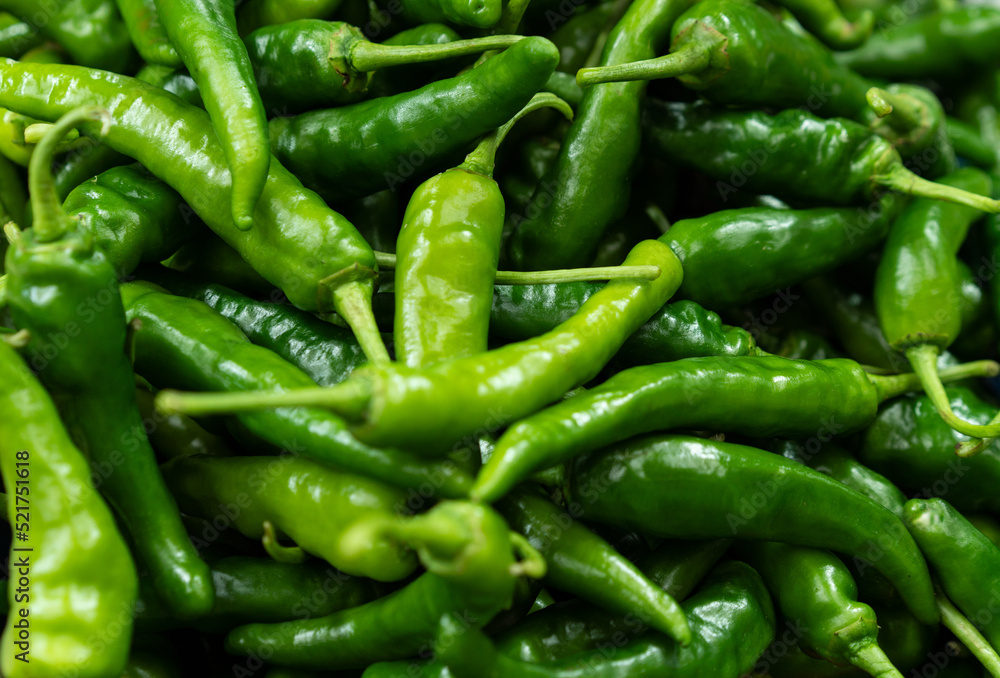many fresh green chili peppers on the market