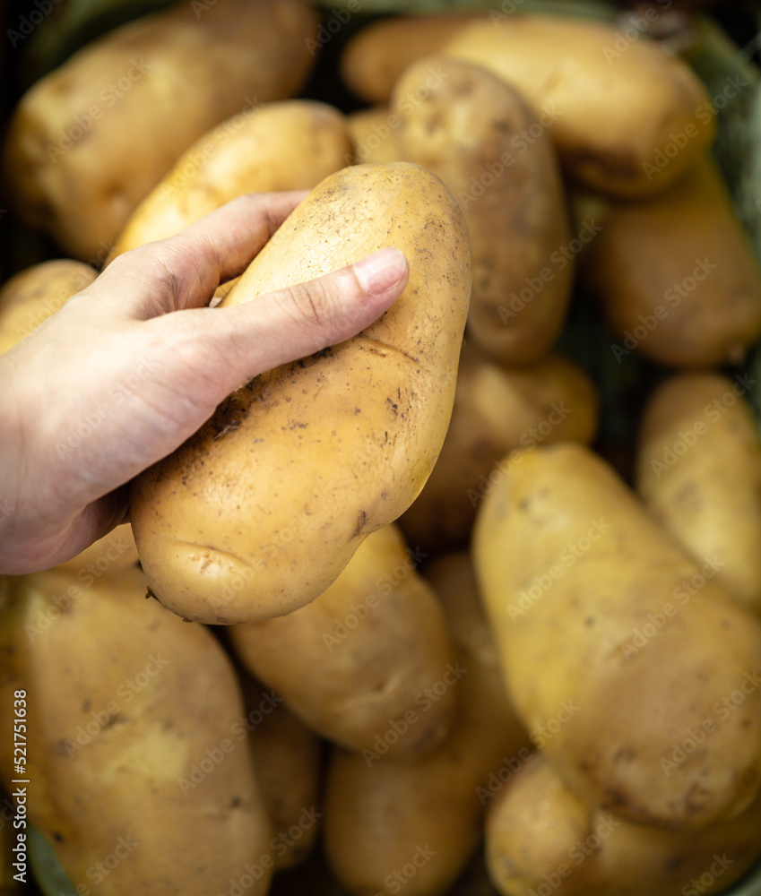 a hand is picking up potatoes in a basket a hand is picking up potatoes in a basket