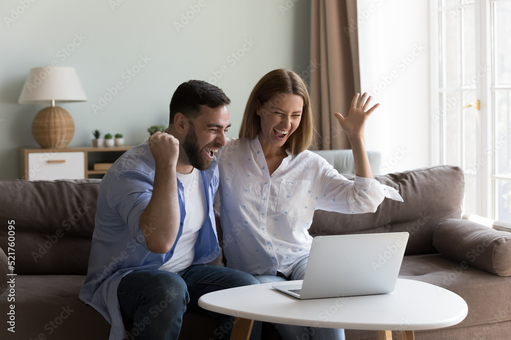 Young couple celebrate online lottery win, screaming with joy looking happy, read great news on laptop, get amazing commercial sale offer or discount. Moment of victory, candid emotions, luck concept Young couple celebrate online lottery win, screaming with joy looking happy, read great news on laptop, get amazing commercial sale offer or discount. Moment of victory, candid emotions, luck concept
