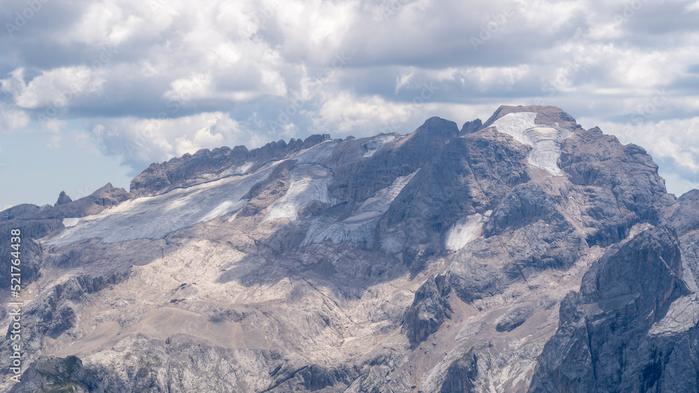 Amazing landscape to the Marmolada and its glaciers during summer time. Melting of glaciers due to global warming. It is the highest mountain of the Dolomites. Italian alps. Summer 2022