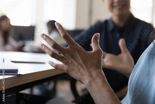 African woman, project leader gesticulate while talk at group meeting in coworking, close up cropped shot. Concept of communication, negotiations, mentoring, client and sales manager meet in office