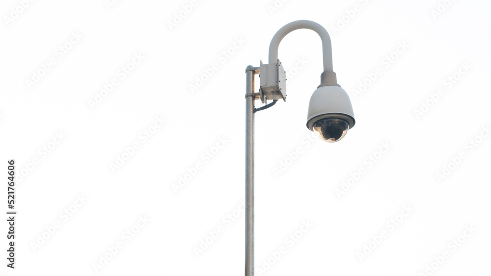 video surveillance camera on a pole against a white sky video surveillance camera on a pole against a white sky