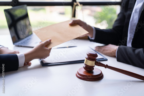 lawyer or attorney who is taking bribes reads the statute of limitations. Consultation between male lawyers and business clients, tax and legal services and corruption firms.