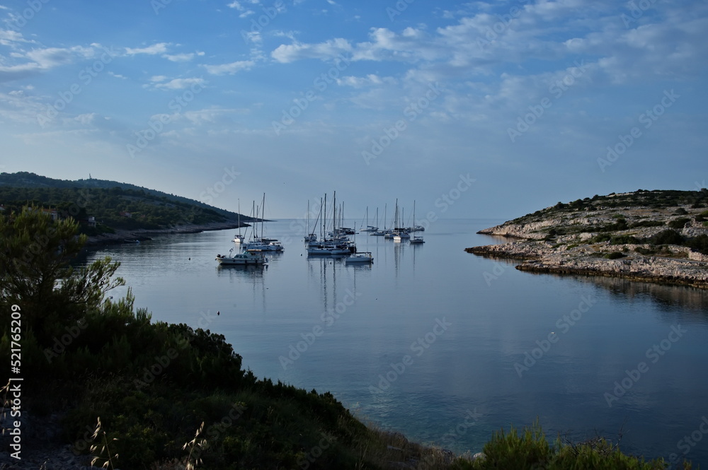 Deep bay in Adriatic sea with sailboats against clear blue sea