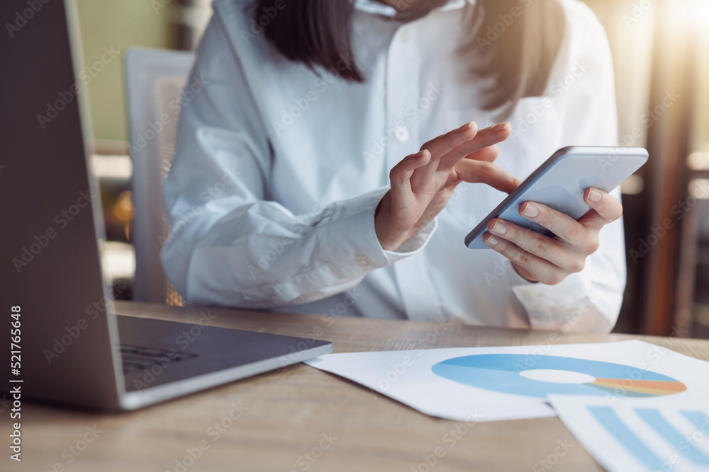 Close up of businesswoman hands using phone while sit on her workplace in office Close up of businesswoman hands using phone while sit on her workplace in office