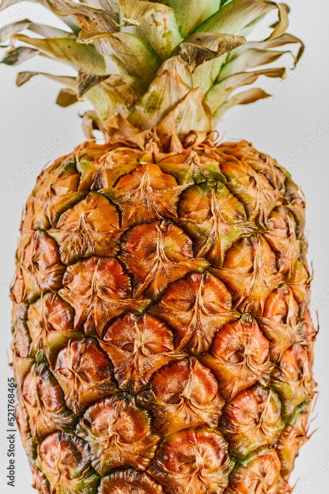 Fototapeta premium Ripe pineapple close-up on a white background with copy Ripe tropical juicy fruit. Delivery prospectus or flyer idea, vertical frame