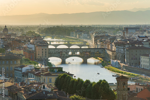 Goldsmiths Old Bridge ('Ponte Vecchio') and other bridges over the River Arno at summet sunset with haze on the horizon , Florence- Firenze, Tuscany, Italy photo
