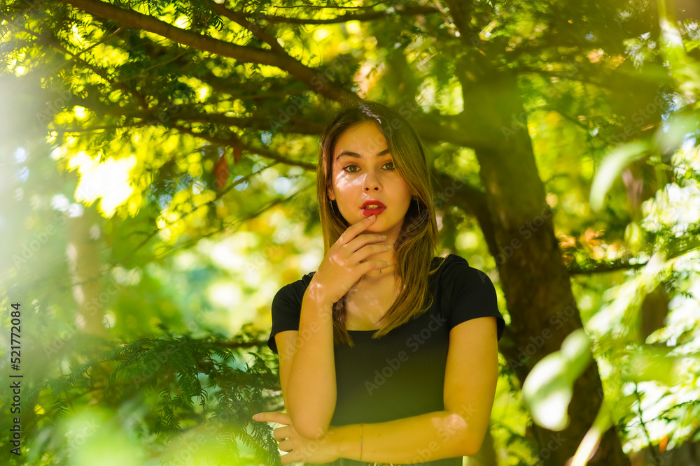 A young brunette woman in nature in the natural park, in the shade of a tree A young brunette woman in nature in the natural park, in the shade of a tree