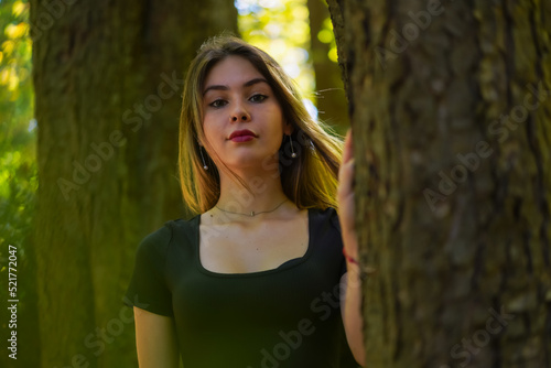 Portrait of a young woman next to a tree in nature in a natural park