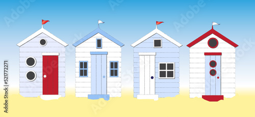 Fotografiet A row of beach huts against blue sky and sand