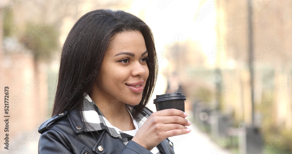 Young black woman outdoors drinking coffee reusalble cup walking city. Young black woman outdoors drinking coffee reusalble cup walking city.