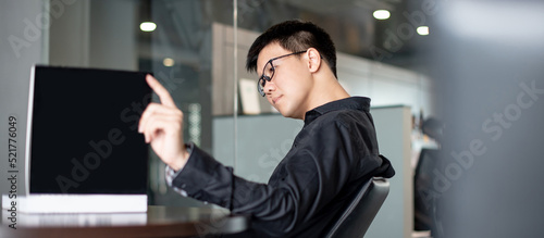 Asian businessman wearing glasses reading book in public library. Education research and self improvement with printed media. World Book Day concept