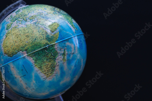 World globe set against a dark black board background. Concept image with copy space available.