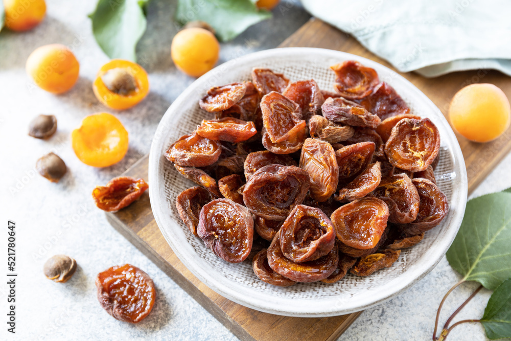 Dried fruits. Dried apricots and raw apricots on a gray stone background. Dried fruits. Dried apricots and raw apricots on a gray stone background.