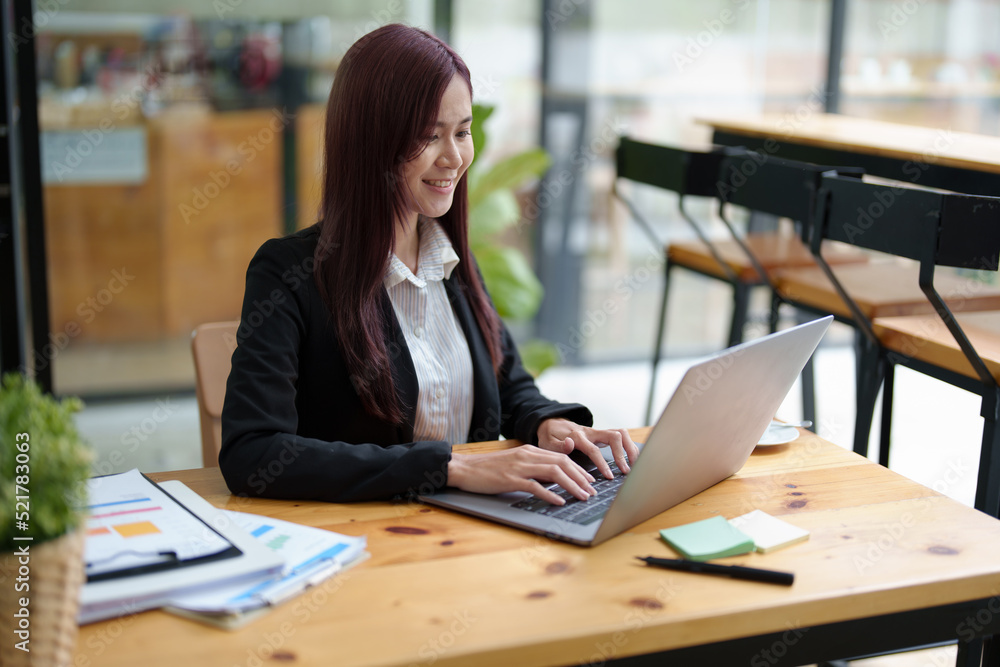 Portrait of a business woman using a computer to work on financial statements Portrait of a business woman using a computer to work on financial statements