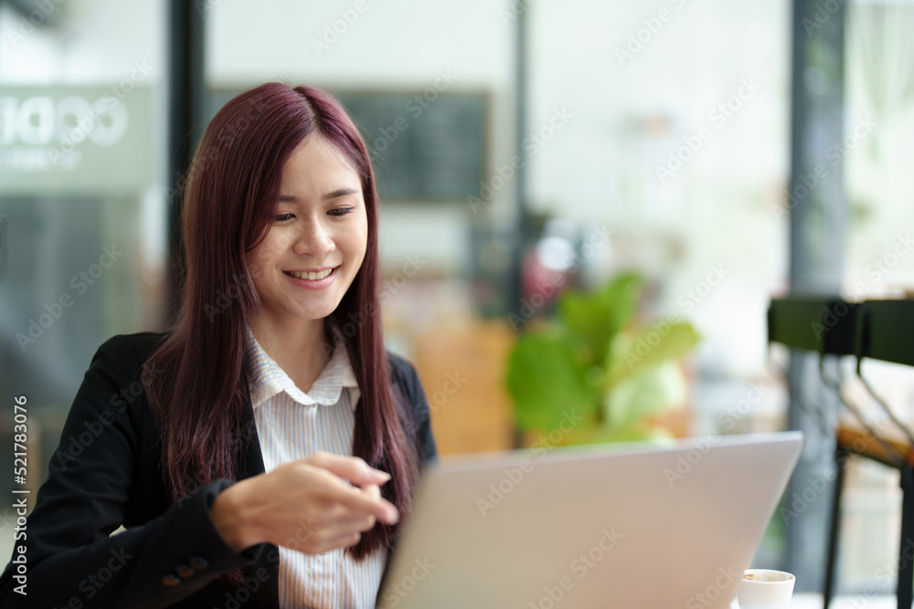 Portrait of a business woman using a computer to work on financial statements Portrait of a business woman using a computer to work on financial statements