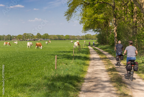 Obraz na płótnie Couple riding their bicycle at a dirt road in Overijssel w salonie