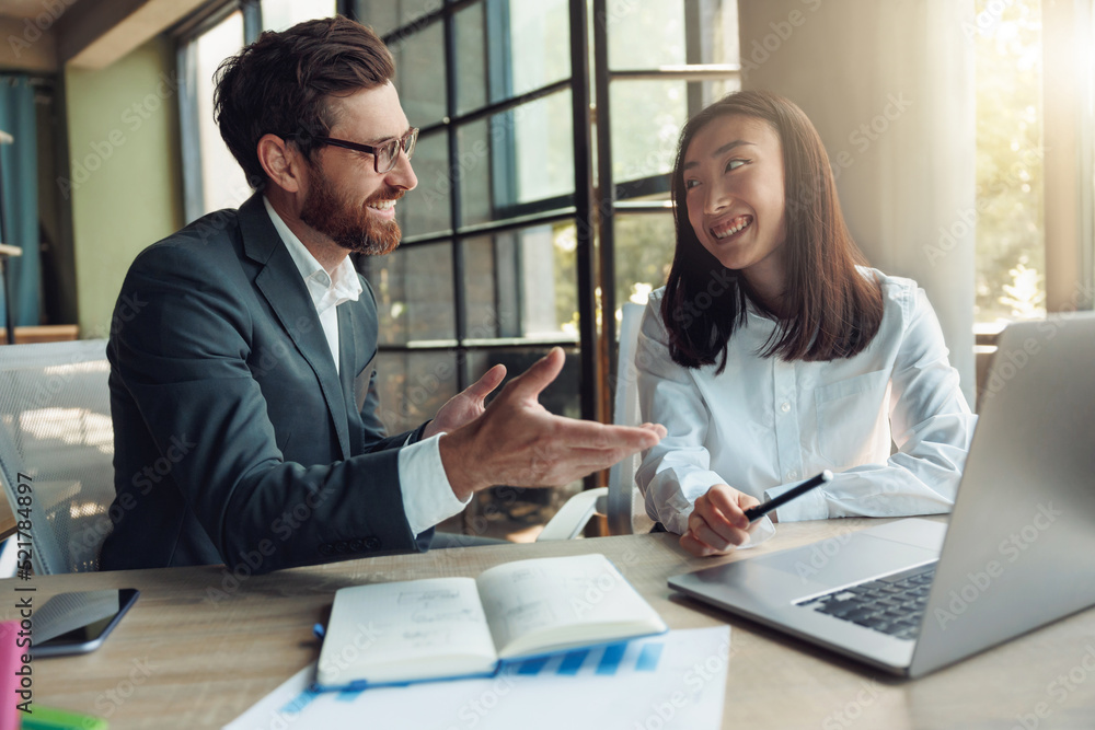 Two smiling business people working in a modern office and discussing a new project Two smiling business people working in a modern office and discussing a new project