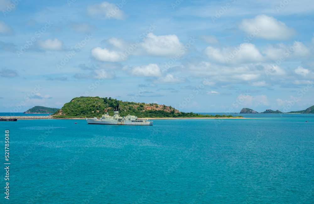 Military warships are stationary beside a small island. against a background of green mountains and clear skies in the Gulf of Thailand, Sattahip, Thailand.