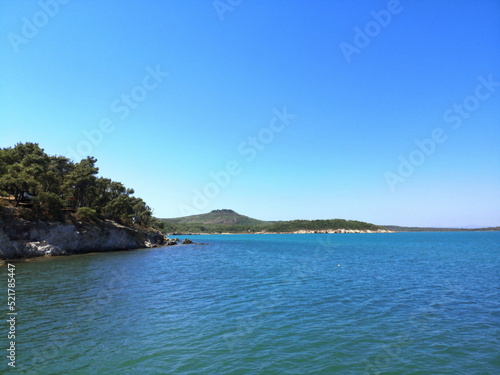 Landschaft mit Felsenküste im Sommer vor blauem Himmel im Sonnenschein in der Bucht vor Ayvalik am Ägäischen Meer in der Provinz Balikesir in der Türkei photo