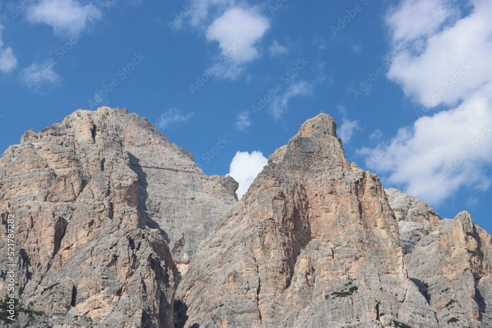 Coravara, Italy-July 16, 2022: The italian Dolomites behind the small village of Corvara in summer days with beaitiful blue sky in the background. Green nature in the middle of the rocks.