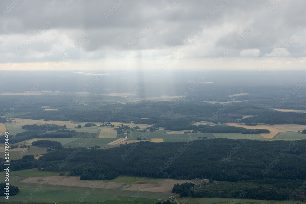Summer aerial photo from shout west part of Finland. Sun trays (god fingers) down from the clouds. 