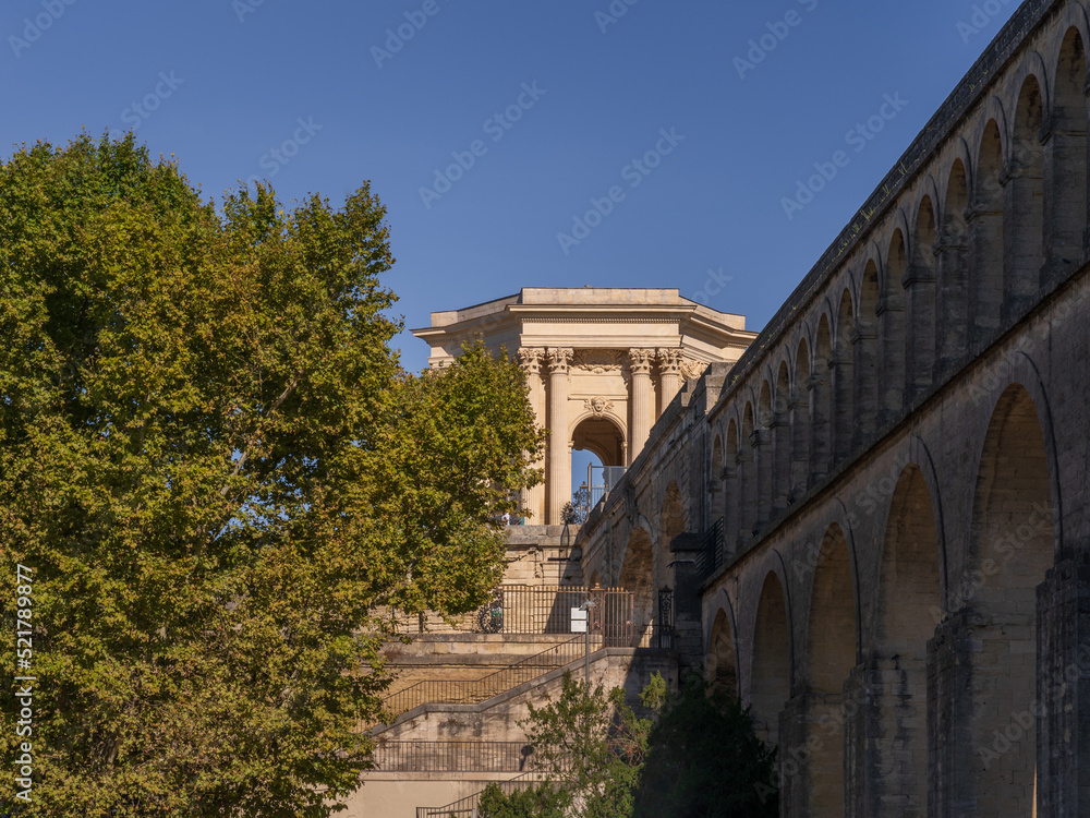 Summer landscape view of St Clement aka Arceaux aqueduct and historic water tower ancient stone buildings, famous landmarks of Montpellier, France