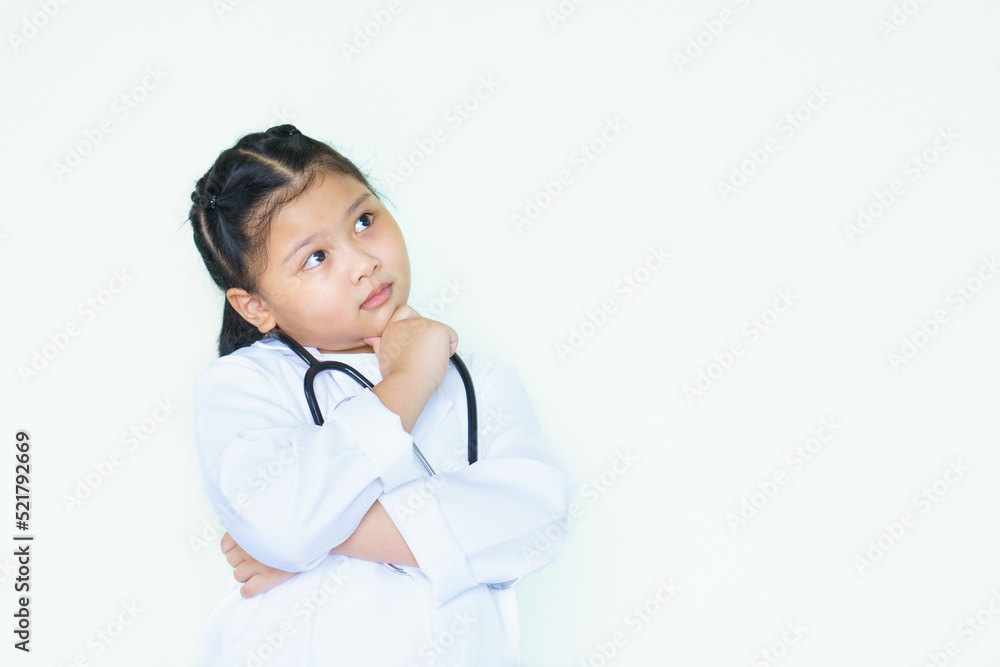 Portrait asian kid girl child dressed medical doctor uniform and stethoscope with question face. shot eye sign on free space background. Cute girl in doctor or nurse uniform thinking. Portrait asian kid girl child dressed medical doctor uniform and stethoscope with question face. shot eye sign on free space background. Cute girl in doctor or nurse uniform thinking.