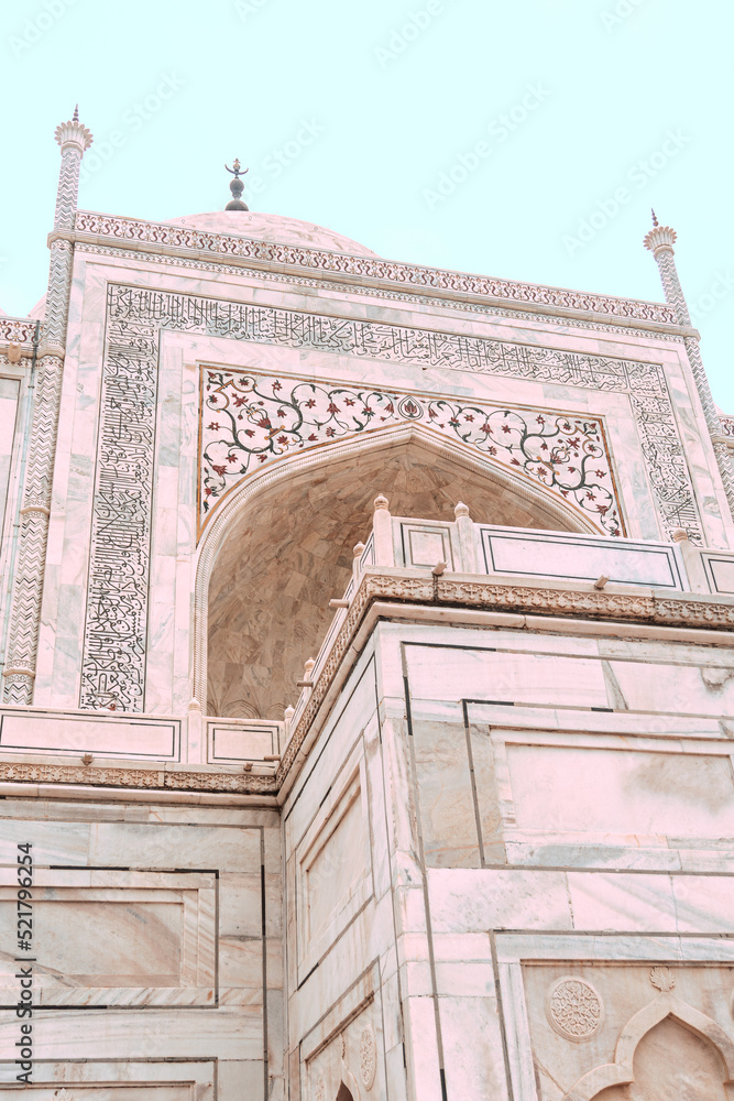 Taj Mahal, islamic ivory-white marble mausoleum, close-up on a historic ornate facade.