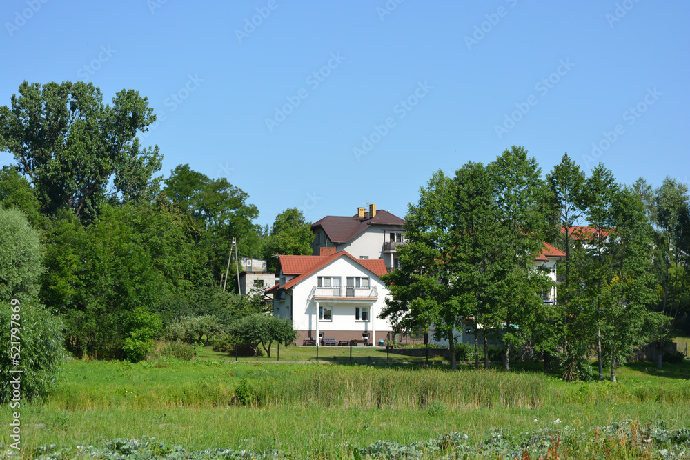 Bright, doll-like, stylish houses, private buildings are located around the amazing nature, the Bug River in the village of Ribenko-Nova of Gmina Wyszków, Masovian Voivodeship, in east-central Poland.