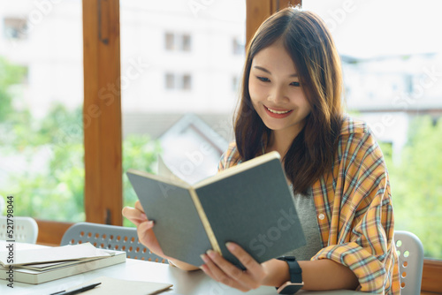 Education and literacy concept, College student girl is reading textbook in college library