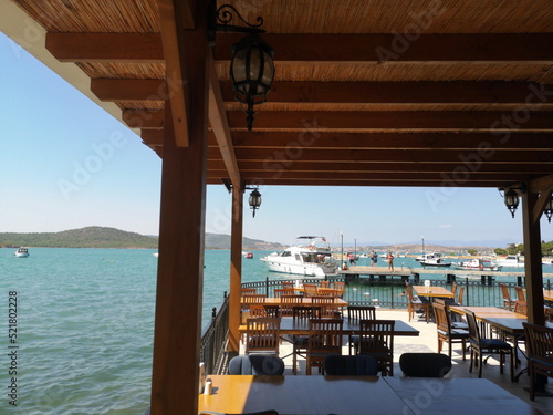 Überdachte Terrasse eines Restaurant mit Blick auf das Meer im Sommer bei Sonnenschein am Strand von Ayvalik in der Provinz Balikesir am Ägäischen Meer in der Türkei photo