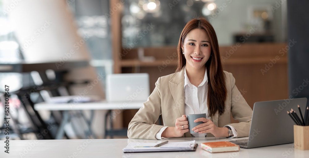 Young asian businesswoman beautiful charming smiling and talking on the mobile phone sitting at the office. Young asian businesswoman beautiful charming smiling and talking on the mobile phone sitting at the office.