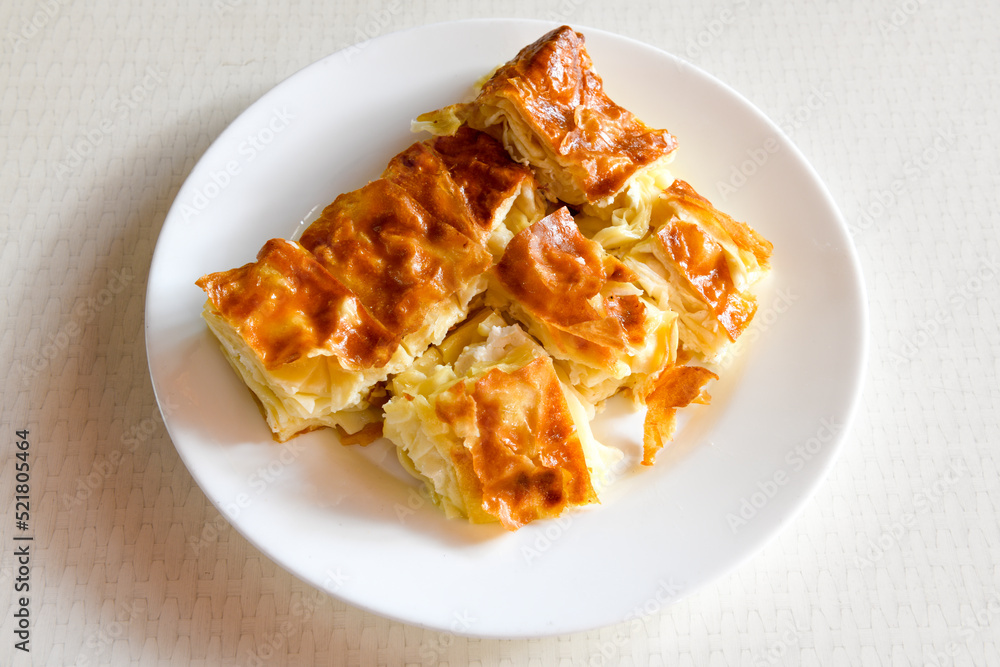 Turkish style meat stuffed filo dough borek served kol boregi. Cheese and minced pie are sliced on a marble background. Turkish name: Kol Boregi, kiymali, peynirli su boregi. Turkish style meat stuffed filo dough borek served kol boregi. Cheese and minced pie are sliced on a marble background. Turkish name: Kol Boregi, kiymali, peynirli su boregi.