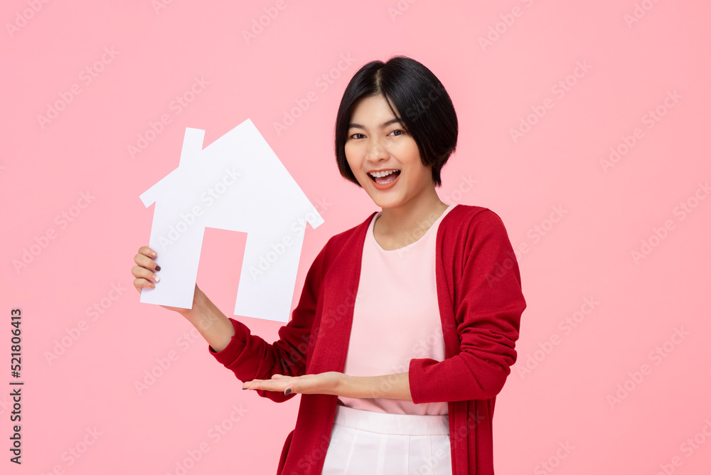 Young pretty Asian woman smiling and holding house model cutout in pink studio isolated background Young pretty Asian woman smiling and holding house model cutout in pink studio isolated background