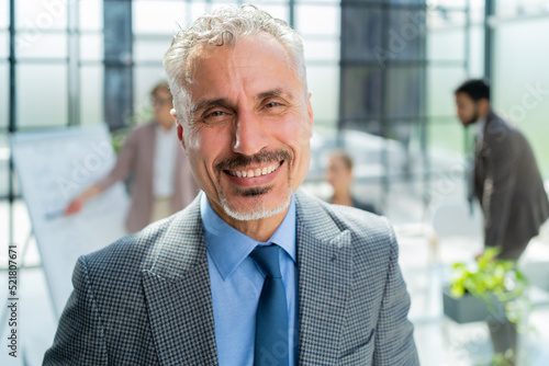 Businessman with colleagues in the background in office.