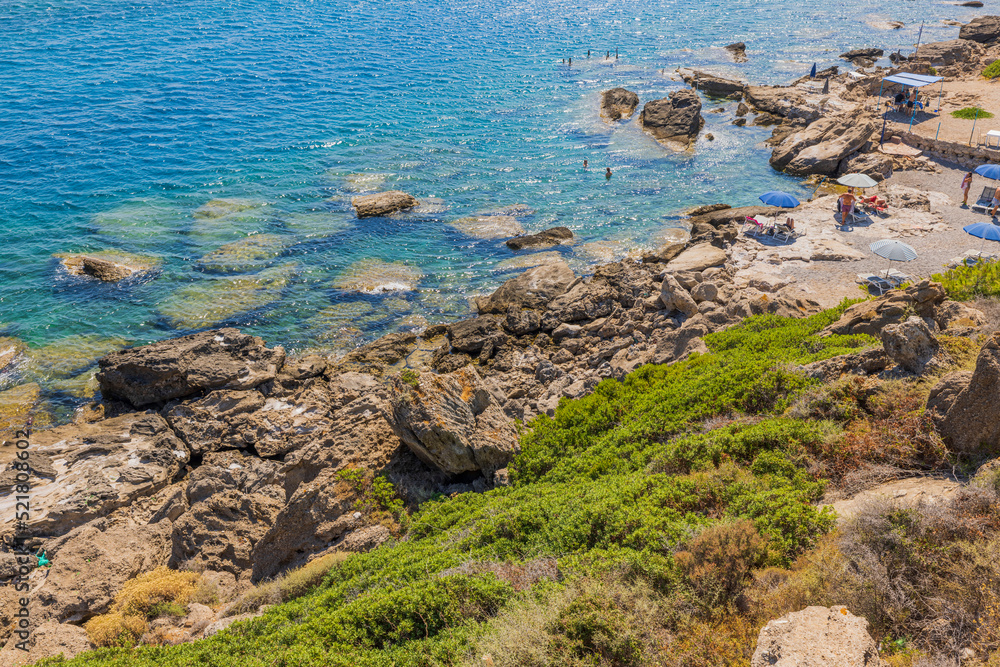 Beautiful view of beach with people on rocky shore in Mediterranean sea. Greece. Beautiful view of beach with people on rocky shore in Mediterranean sea. Greece.