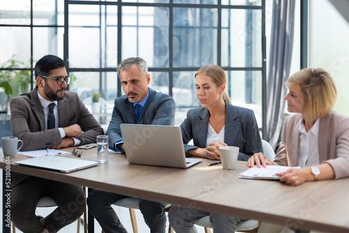 Group of business partners discussing ideas and planning work in office.