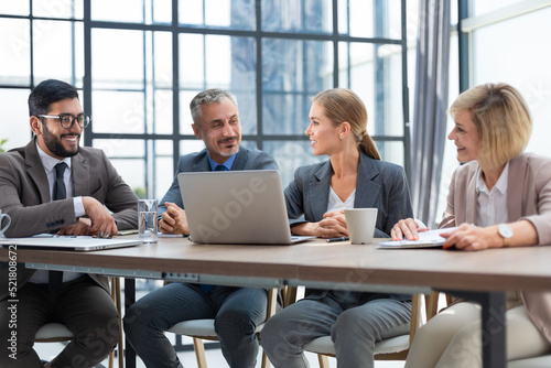 Group of business partners discussing ideas and planning work in office.