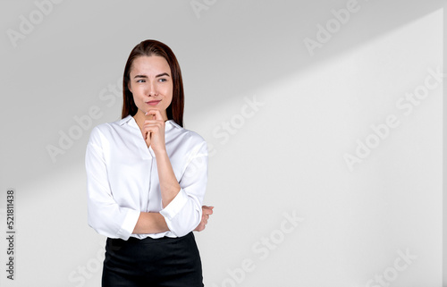 Pondering attractive businesswoman wearing formal wear is standi photo