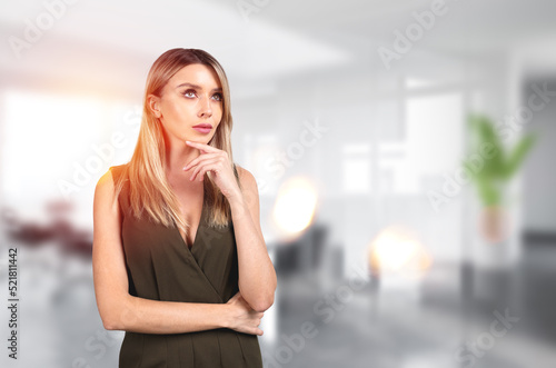 Pondering attractive businesswoman wearing formal wear is standi