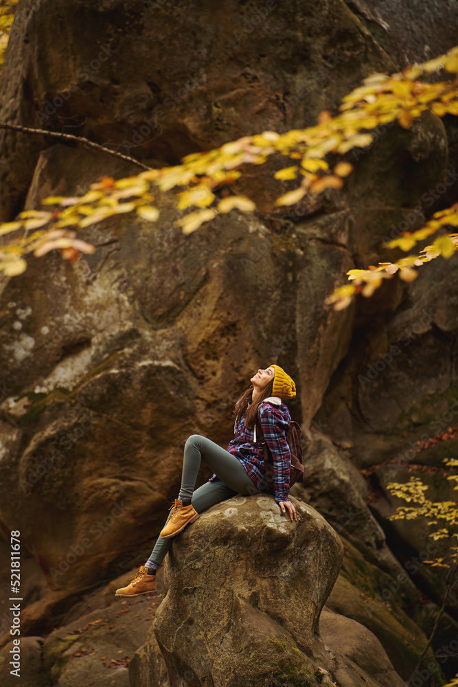 Vertical inspiring wanderlust shot of travel hipster woman relaxing in the nature, sits on stone in old woods with mossy boulders. concept of people love for nature and planet earth Vertical inspiring wanderlust shot of travel hipster woman relaxing in the nature, sits on stone in old woods with mossy boulders. concept of people love for nature and planet earth