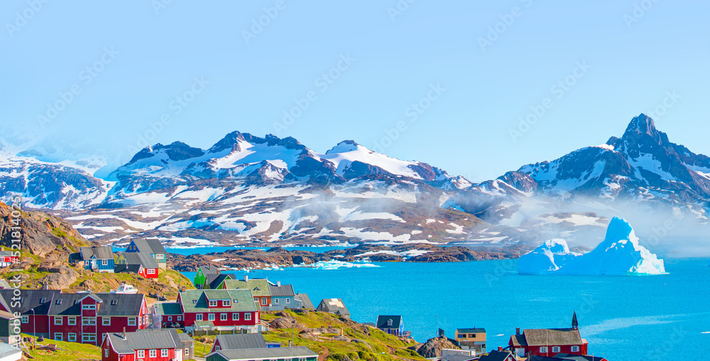 Melting icebergs by the coast of Greenland, on a beautiful summer day - Picturesque village on coast of Greenland - Colorful houses in Tasiilaq, East Greenland