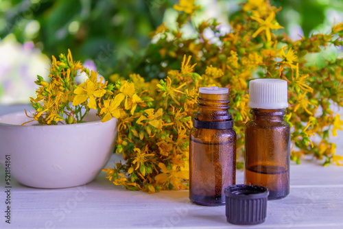 St. John's wort flower oil in a glass bottle. on a wooden background.